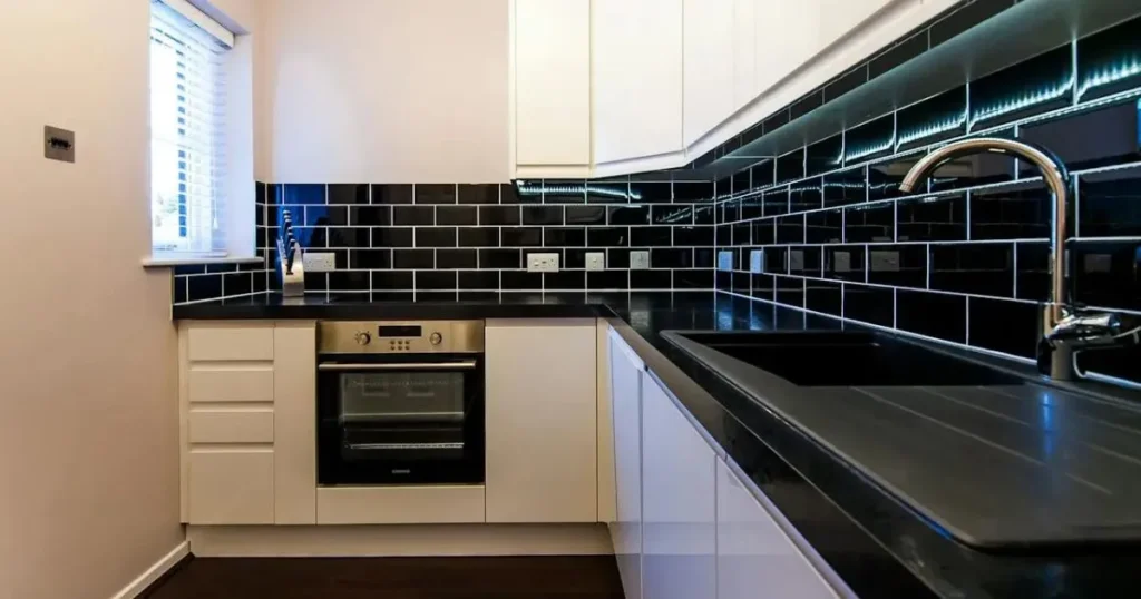 Modern kitchen with white cabinets accented by bold black hardware details.